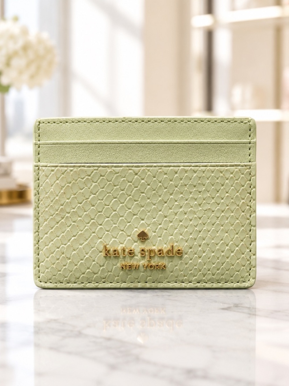 kate spade light green snake-embossed card holder with gold logo